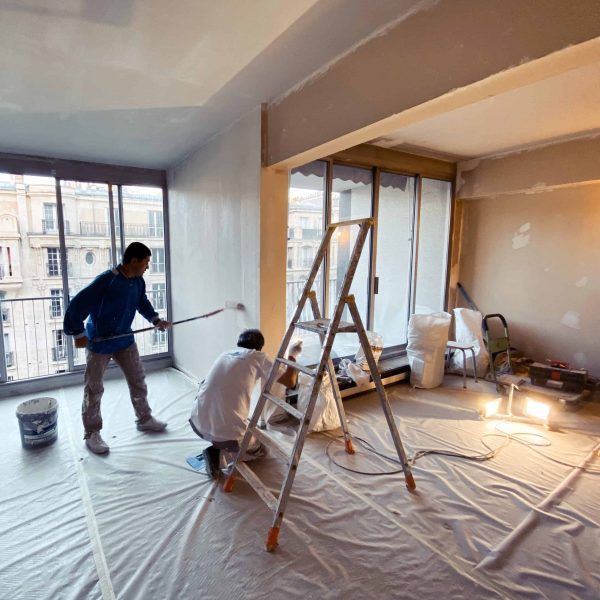 Deux ouvriers qui rénovent les murs d'un appartement